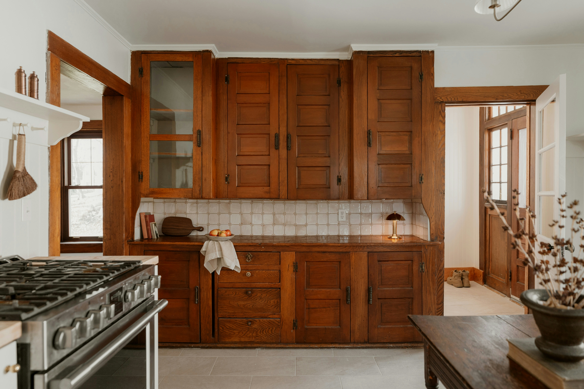 Vintage wood cabinetry with a tiled backsplash